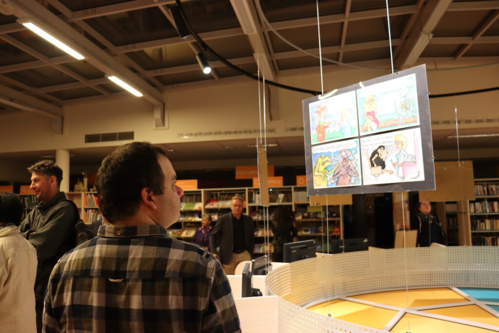 Mężczyzna w kraciastej koszuli ogląda wystawę.