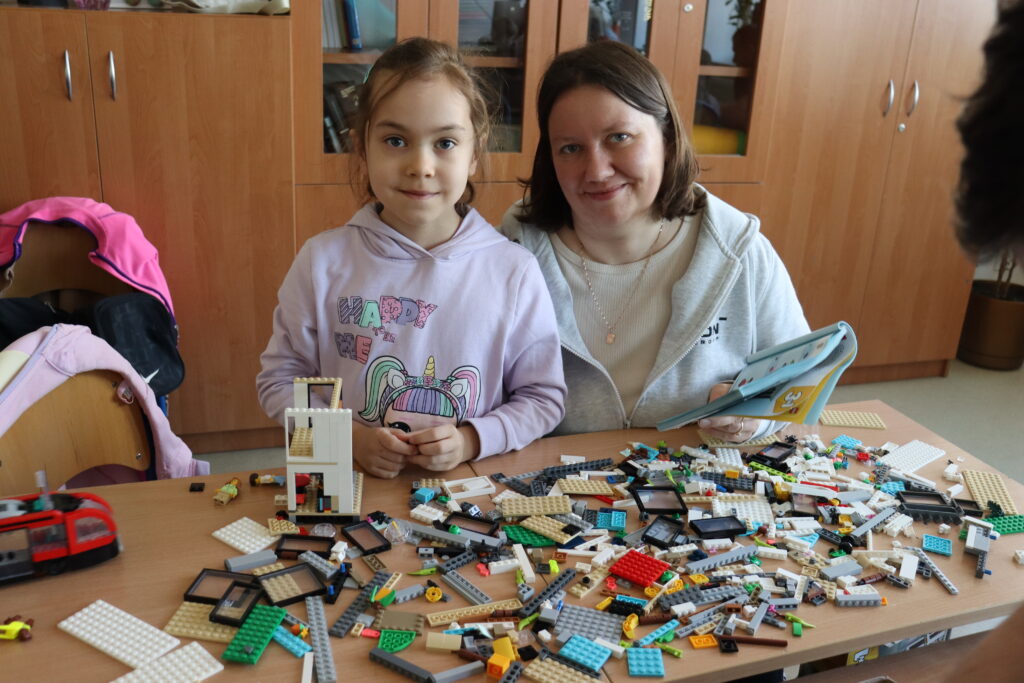 Dziewczynka i mama budują z klocków.