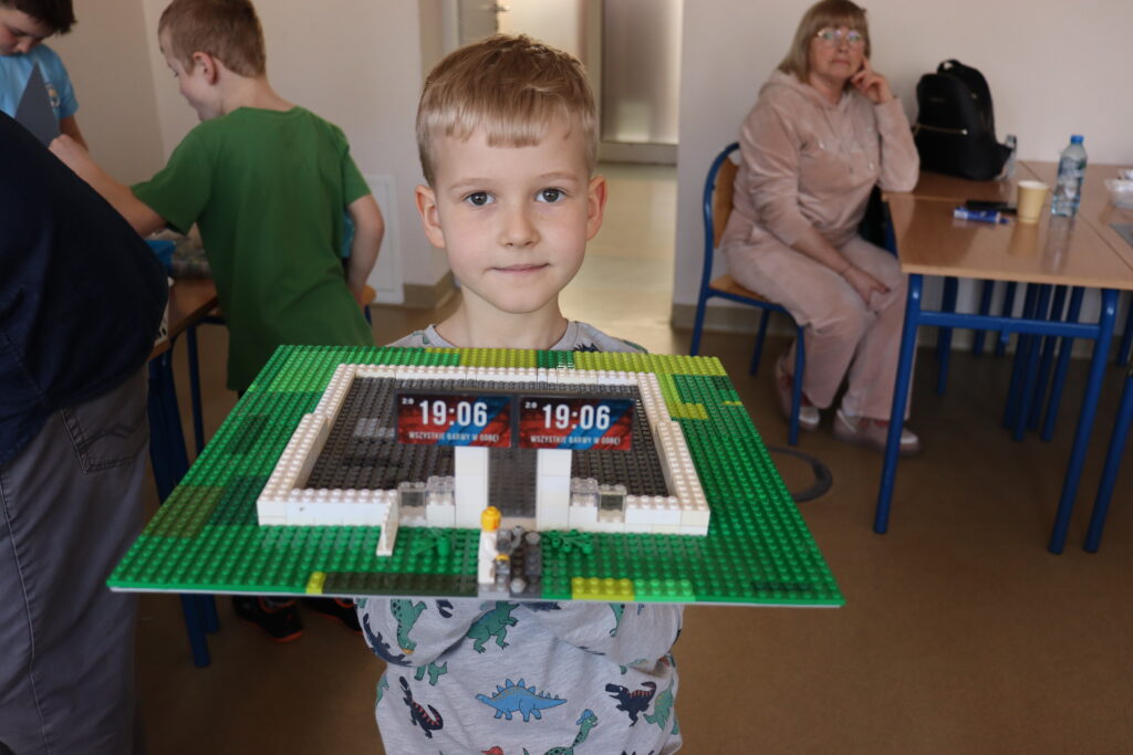 Chłopiec pokazuje zbudowany przez siebie budynek.