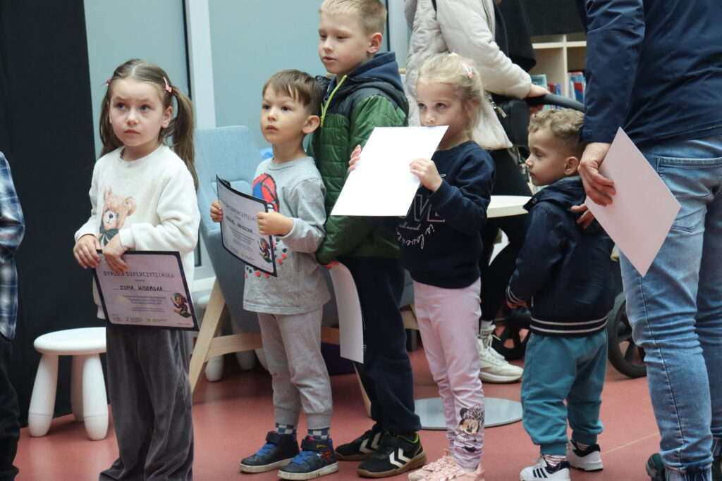 Dzieci z dyplomami czekają na wręczenie nagród.