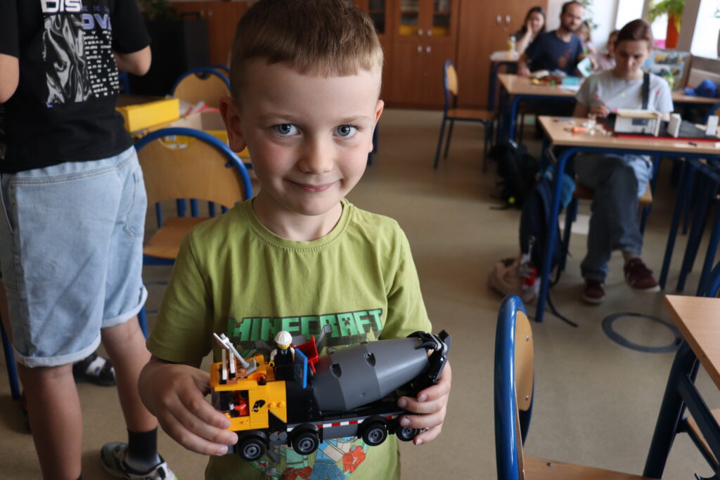 Chłopiec pokazuje betoniarkę z klocków LEGO.