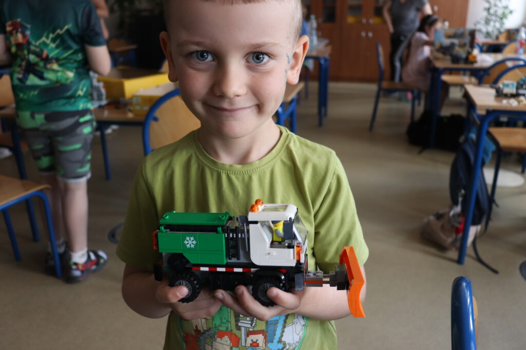Chłopiec pokazuje pług śnieżny z LEGO.