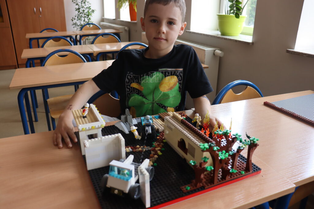 Chłopiec i jego dużą budowla z LEGO.